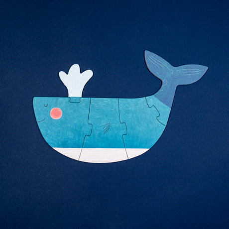 Blue Londji whale jigsaw puzzle for kids on a dark blue background, featuring five interlocking wooden-style pieces.