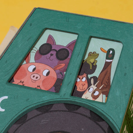 Close-up of a Londji Farmtastic puzzle box featuring a purple cat in sunglasses, a pig, frog, duck, and sheep.