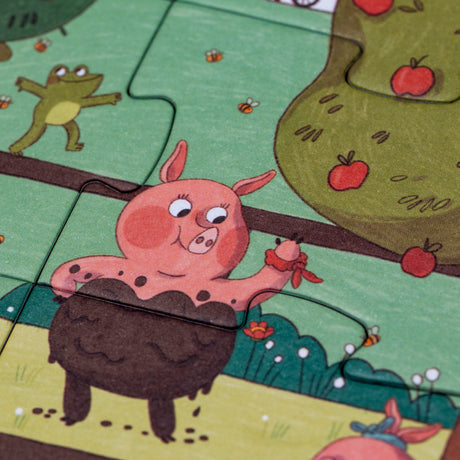 Close-up of a Londji Farmtastic puzzle piece featuring a pink pig in mud, a frog, and an apple tree.