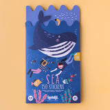 Colorful packaging with a playful ocean theme. Features a smiling whale, divers, and fish. Text: "Sea 150 Stickers." Cheerful and whimsical tone.
