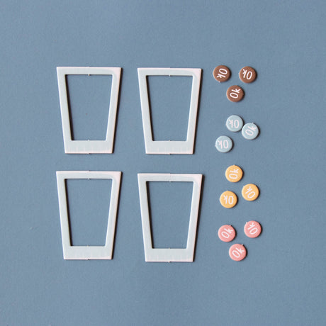 Londji Shakes board game components featuring four cup-shaped frames and colorful "OK" tokens on a blue background.