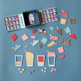Londji Shakes game with colorful milkshake puzzle pieces, menu cards, and game tokens on a blue background.