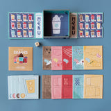 Londji Shakes tiny board game with colorful milkshake cards, menus, dice, and box on a blue background.