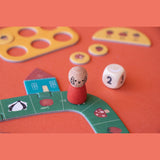 Londji Tiny Game Strawberries featuring wooden dog pawn, dice, and colorful forest-themed game board pieces.