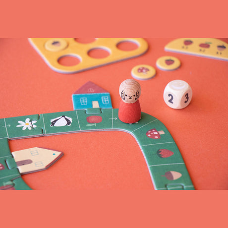 Londji Tiny Game Strawberries board game with wooden character peg, number die, and colorful forest path tiles.