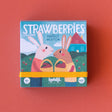 Londji Strawberries Tiny Game box featuring two illustrated bunnies holding baskets of strawberries on a red background.