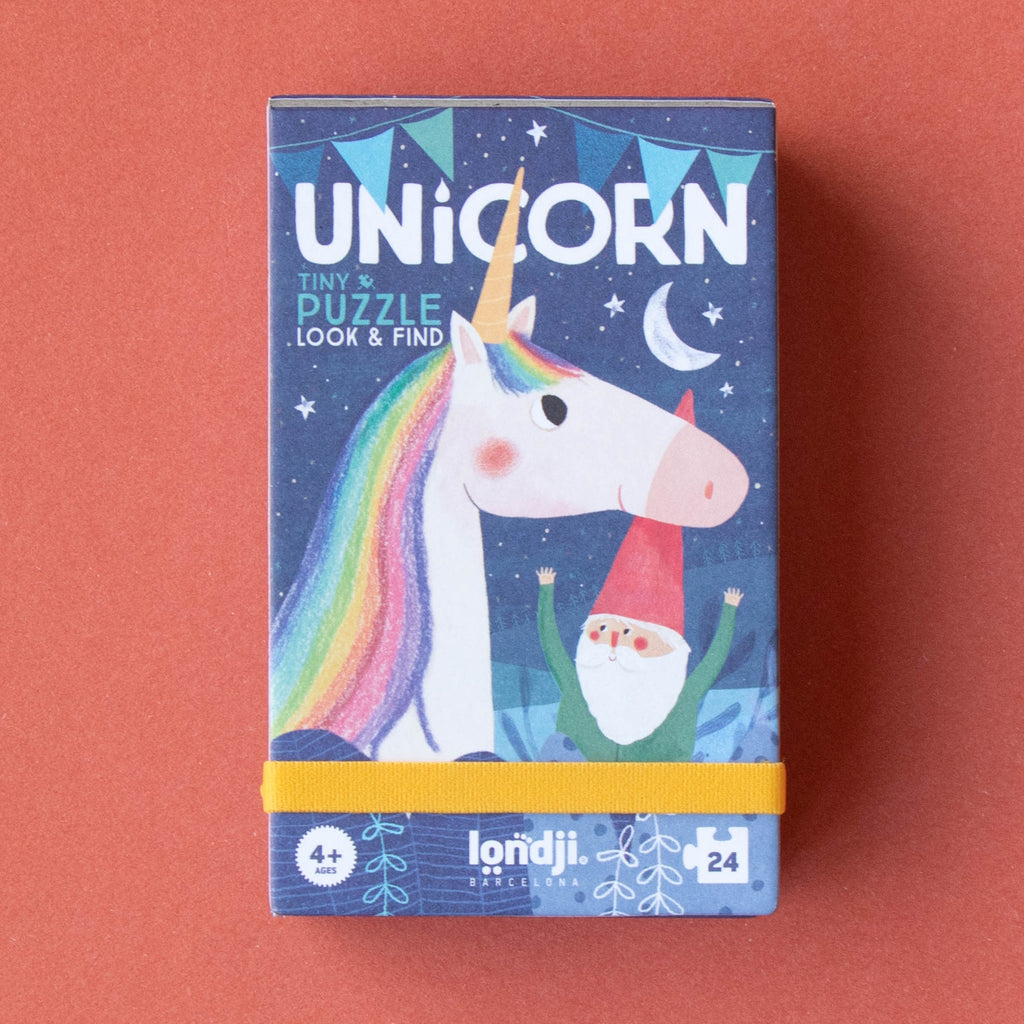 Colorful puzzle box featuring a whimsical unicorn with a rainbow mane and a cheerful gnome under a night sky. Text reads “UNICORN Tiny Puzzle Look & Find.”
