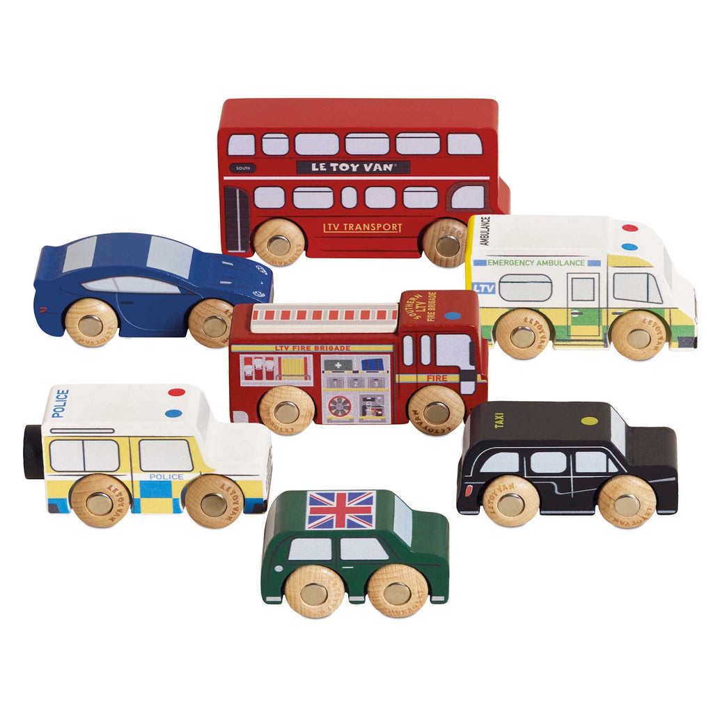 Toy wooden vehicles including a red double-decker bus, police car, ambulance, fire truck, green car, and black taxi. Playful and colorful.