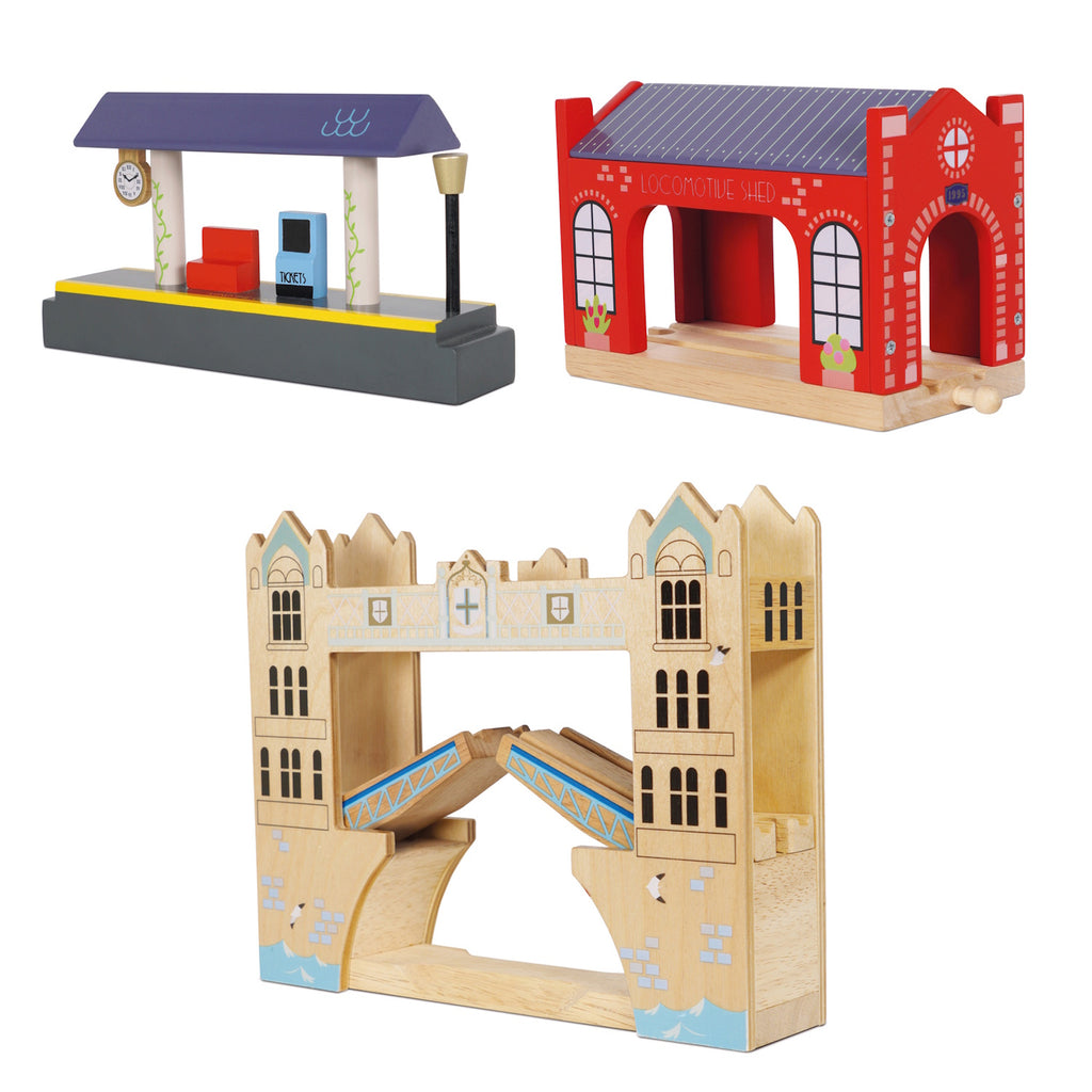 Wooden toy set featuring a red locomotive shed, a train station platform with a clock and lamp, and a detailed bridge resembling a well-known landmark.