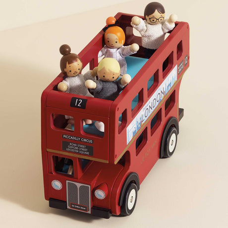 Red wooden double-decker London bus toy carrying four small wooden passenger figures.
