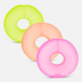 Three colorful ring-shaped memory gel stress loops in lime green, peach, and pink.