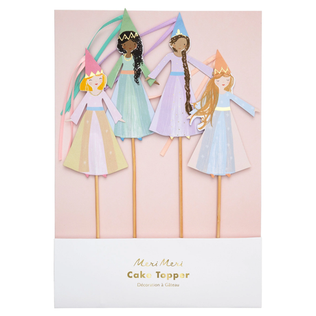 Packaged Meri Meri magical princess cake toppers with ribbon hats and wooden picks displayed on a pink card.