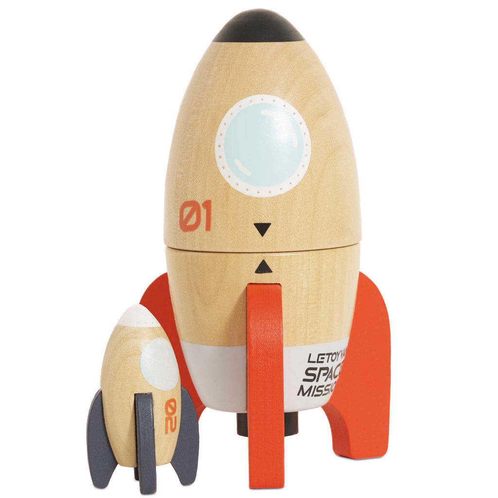 Wooden toy rockets on a white background, featuring a large beige rocket with red fins and a smaller dark blue and beige rocket, conveying playfulness.