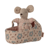 A tiny soft mouse wearing a pink knitted outfit, snug inside a floral-patterned rose-colored fabric carry cot with handles—perfect for imaginative play and Maileg dollhouse collections.
