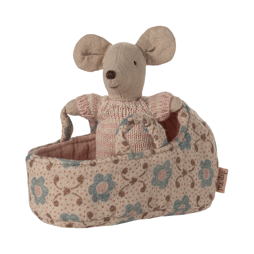 A tiny soft mouse wearing a pink knitted outfit, snug inside a floral-patterned rose-colored fabric carry cot with handles—perfect for imaginative play and Maileg dollhouse collections.