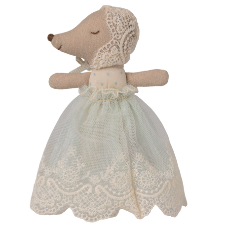 A soft toy with a mouse-like snout and closed eyes, wearing a delicate lace bonnet and a pale blue, lace-trimmed dress, set against a white background.