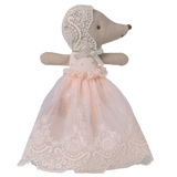 A plush hedgehog toy is dressed in a delicate, pink lace dress with a matching lace bonnet. The background is solid white, emphasizing the toy's elegance.