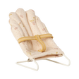 Soft, pink miniature doll chair with floral patterns on a white wire frame, featuring a yellow fabric strap. The design feels delicate and vintage.