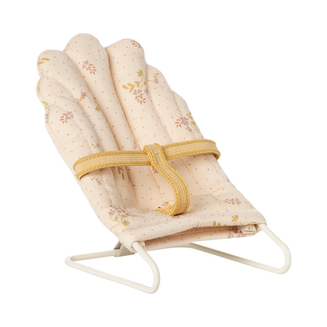 Soft, pink miniature doll chair with floral patterns on a white wire frame, featuring a yellow fabric strap. The design feels delicate and vintage.