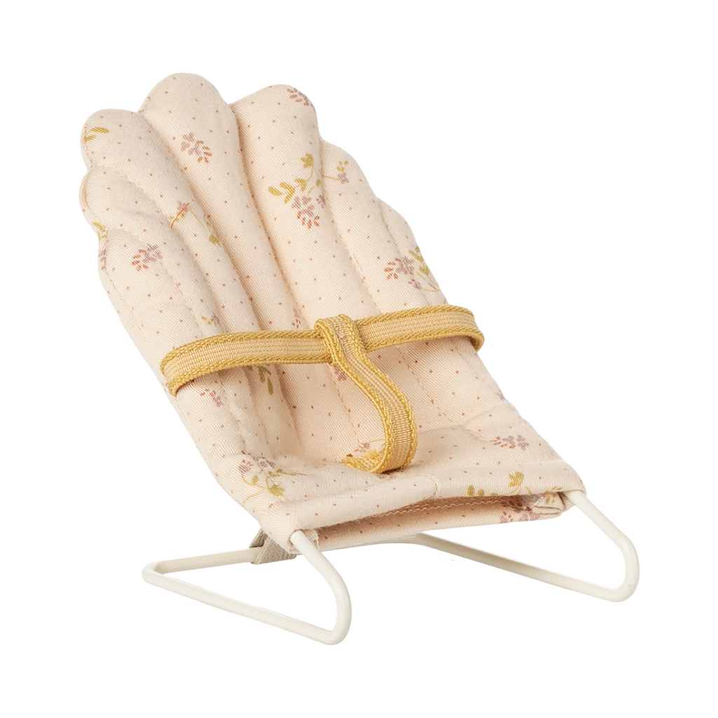 Soft, pink miniature doll chair with floral patterns on a white wire frame, featuring a yellow fabric strap. The design feels delicate and vintage.