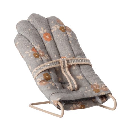 Miniature gray floral baby chair with soft padding and metal frame. It features a harness, scattered orange and brown flowers, and a cozy, vintage feel.