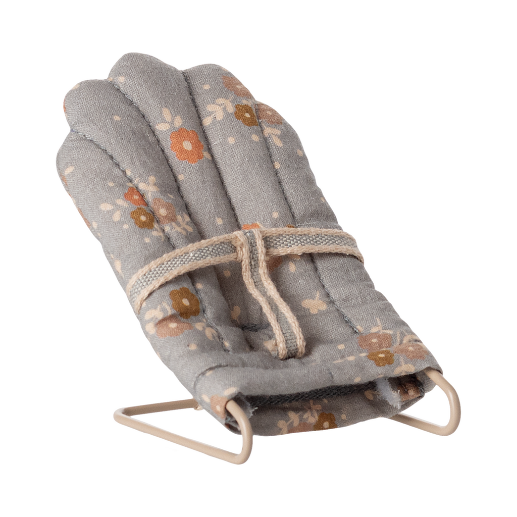Miniature gray floral baby chair with soft padding and metal frame. It features a harness, scattered orange and brown flowers, and a cozy, vintage feel.
