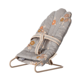 Miniature gray floral baby chair with soft padding and metal frame. It features a harness, scattered orange and brown flowers, and a cozy, vintage feel.