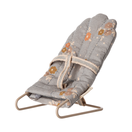 Miniature gray floral baby chair with soft padding and metal frame. It features a harness, scattered orange and brown flowers, and a cozy, vintage feel.