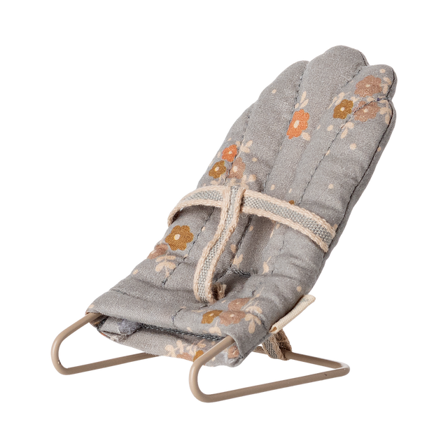 Miniature gray floral baby chair with soft padding and metal frame. It features a harness, scattered orange and brown flowers, and a cozy, vintage feel.