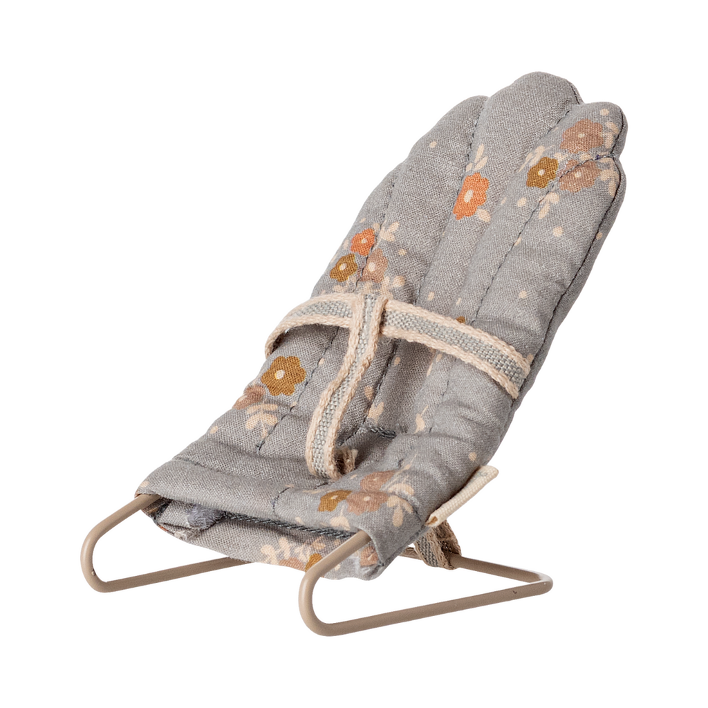 Miniature gray floral baby chair with soft padding and metal frame. It features a harness, scattered orange and brown flowers, and a cozy, vintage feel.