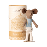 A cute toy mouse in a blue shirt with suspenders stands beside a cylindrical box featuring an illustration of an ornate building, labeled "Romeo & Juliet."