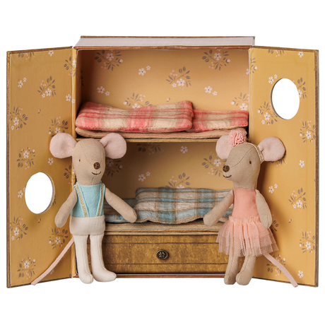 Two fabric toy mice inside a floral bunk bed box, one in a blue vest and one in a pink ballet tutu.