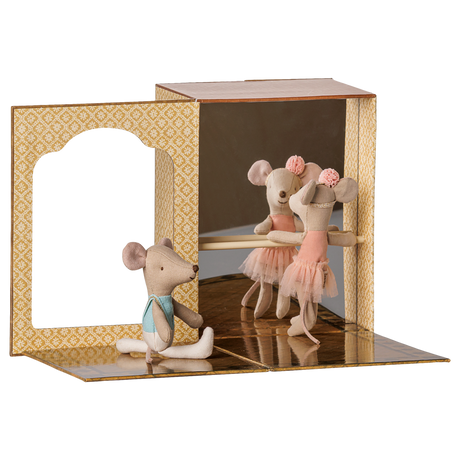 Two fabric toy mice practice ballet inside a miniature cardboard dance studio with a mirror and barre.