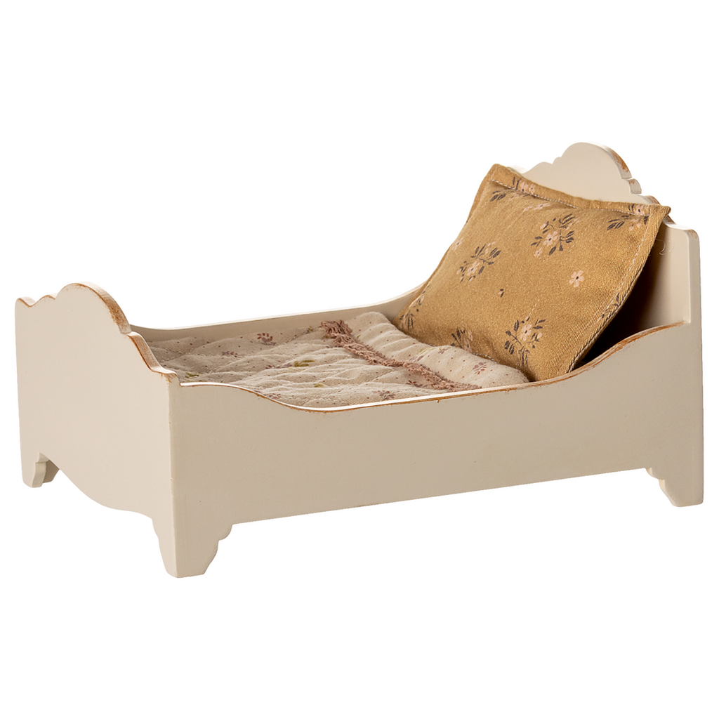 A vintage-style miniature bed with a quilted mattress and a decorative gold pillow, showcasing a charming rustic design in a white background.