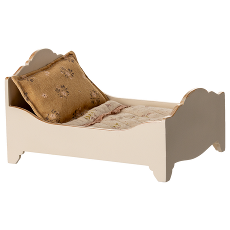 A vintage-style miniature bed with a quilted mattress and a decorative gold pillow, showcasing a charming rustic design in a white background.
