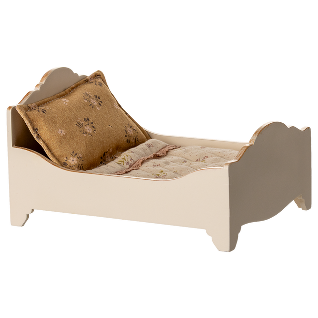A vintage-style miniature bed with a quilted mattress and a decorative gold pillow, showcasing a charming rustic design in a white background.
