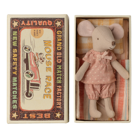 Cute toy mouse in pink polka-dot outfit lies in a small open box resembling a vintage matchbox labeled "Mouse Race," next to colorful bedding.