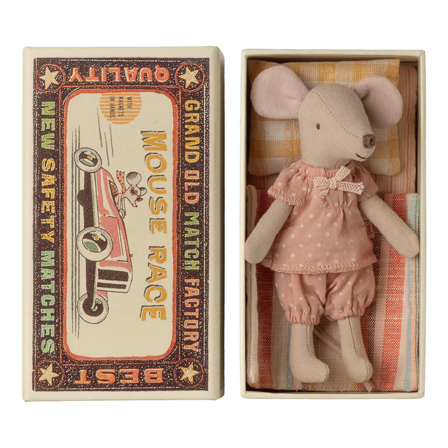 Cute toy mouse in pink polka-dot outfit lies in a small open box resembling a vintage matchbox labeled "Mouse Race," next to colorful bedding.