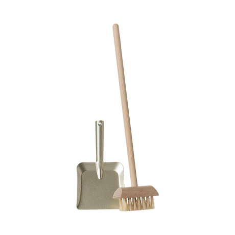 A miniature dustpan with a metal finish and a wooden-handled broom with natural bristles are placed upright on a plain background, evoking simplicity and cleanliness.