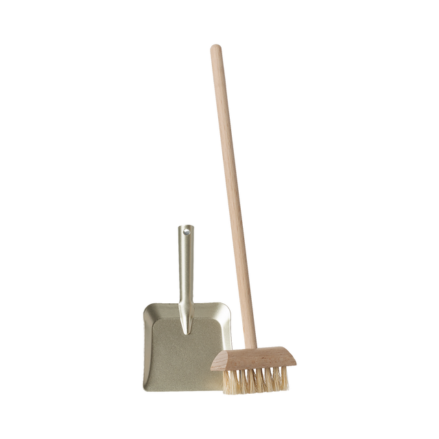 A miniature dustpan with a metal finish and a wooden-handled broom with natural bristles are placed upright on a plain background, evoking simplicity and cleanliness.