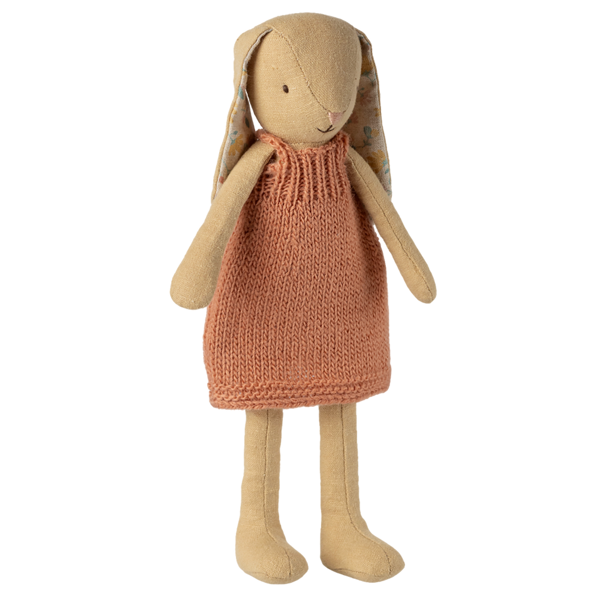 A plush rabbit toy wearing a knitted orange dress stands against a white background. It has long ears, simple stitched features, and a soft, cozy appearance.