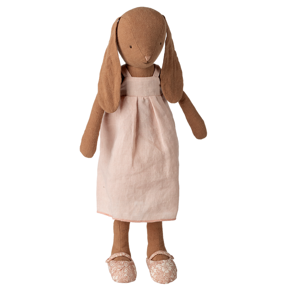 Stuffed rabbit toy with long ears, wearing a light pink dress and floral-patterned shoes, set against a white background, conveying a vintage charm.