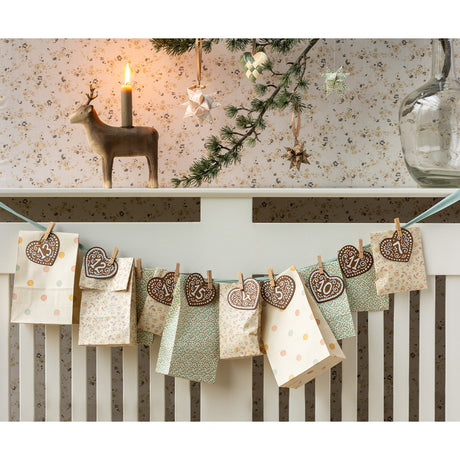 Maileg Christmas advent calendar garland with patterned paper gift bags and numbered heart wooden tags.