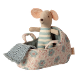 Featuring a tiny mouse in a soft blue-and-white striped onesie, resting in a floral-patterned fabric carry cot with handles and a knitted blue blanket—perfect for nurturing play and Maileg dollhouse setups.