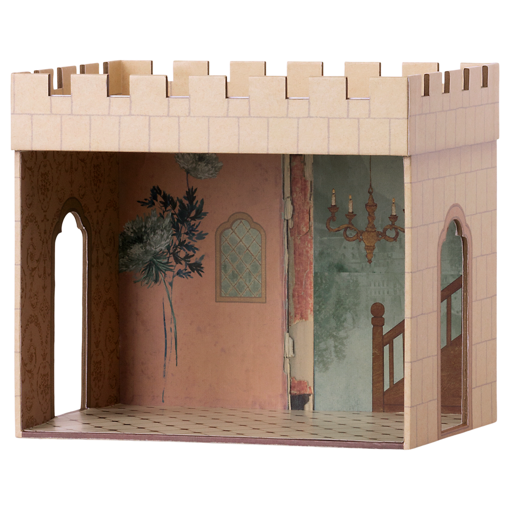 Miniature cardboard dollhouse room with a castle exterior, intricate wallpaper, staircase mural, and chandelier. Arched doorways add an elegant touch.