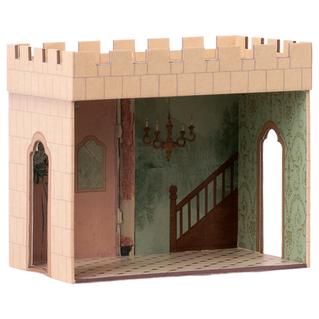 Miniature cardboard dollhouse room with a castle exterior, intricate wallpaper, staircase mural, and chandelier. Arched doorways add an elegant touch.