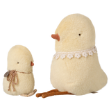Two plush bird toys on a white background: a small chick with a scarf and a larger bird with a lace collar, both in soft, pale yellow fabric.