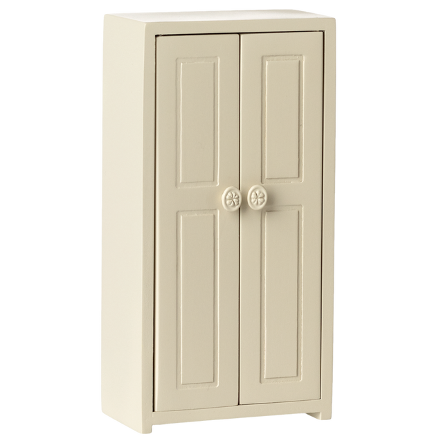 A small cream-colored cupboard with two panelled doors, each featuring a round flower-patterned knob, set against a plain white background.