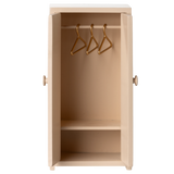 A beige, wooden wardrobe with open doors showing three golden hangers on a rail inside. The design is simple and minimal against a white background.