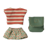 Striped red and white top, floral-patterned green skirt, and a teal leather pouch on a white background. The items appear playful and colorful.